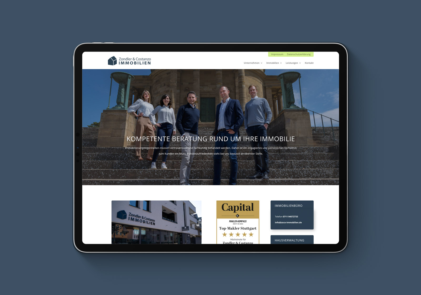 ZONDLER---Startseite-ipad Tablet, das die Website von Zondler & Contour Immobilien zeigt, mit mehreren Personen im Vordergrund.
